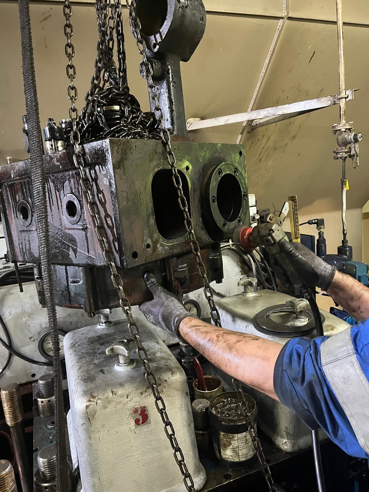Hands-on service of a heavy engine component on a chain hoist